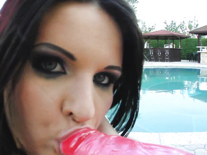 All this slutty babe with dark hair needs for happiness is her big pink dildo. She is torturing her wet holes with this toy next to the pool.